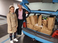 Sanne en Marja van Waveren naast een auto, volgeladen met pakketten