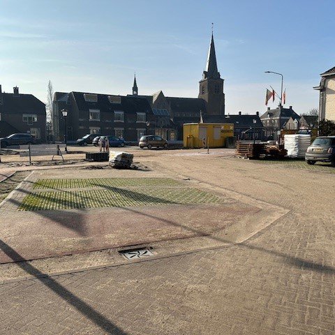 Het vernieuwde dorpsplein met een aantal parkeervakken in beeld.