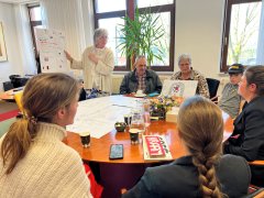 kinderen leggen het plan voor een kinderboerderij uit aan burgemeester Annemieke van de Ven