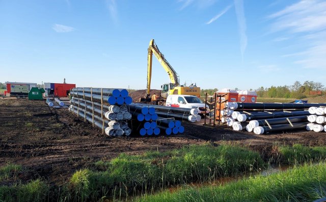 Persleidingen liggen klaar in het veld voor aanleg in de grond