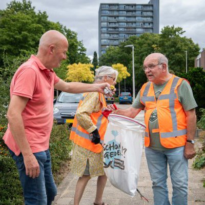 Foto van drie mensen die afval verzamelen