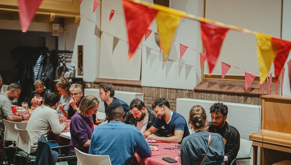 Mensen aan een tafel met slingers.