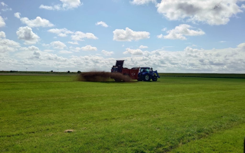 De compost van de compostril wordt over het land uitgestrooid