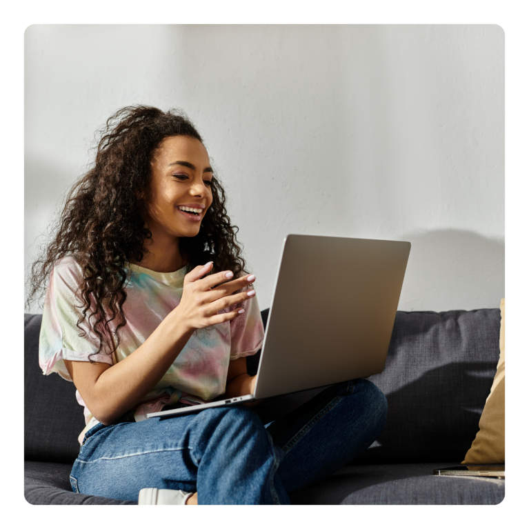 Young adult woman smiles at laptop