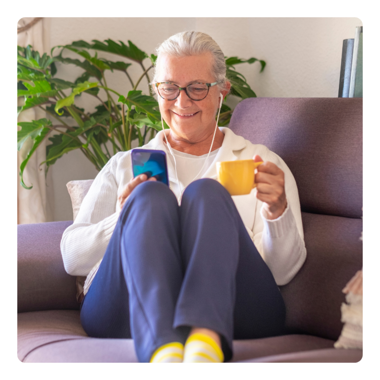 Oudere vrouw kijkt lachend naar telefoon