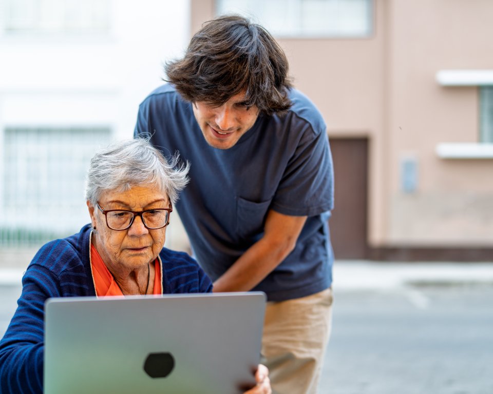 Woman behind laptop gets help from young man