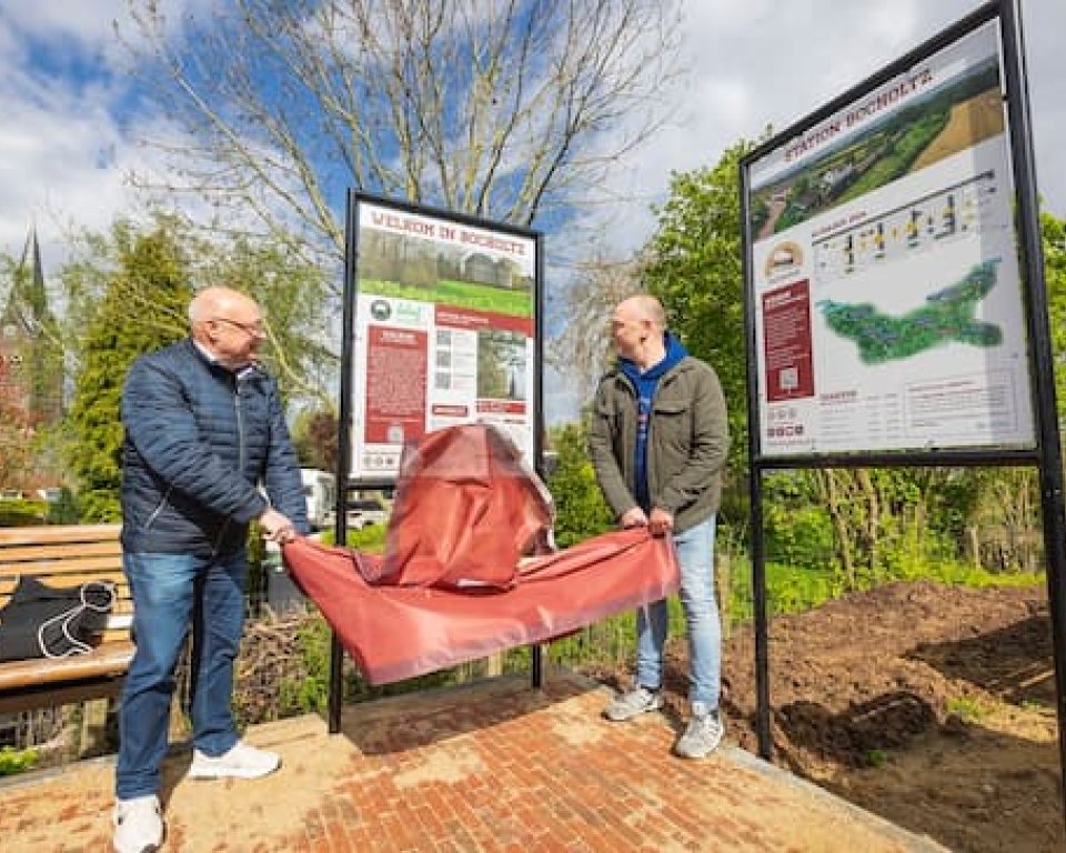 Afbeelding van wethouder Hodinius die het bord bij het perron in Bocholtz onthult