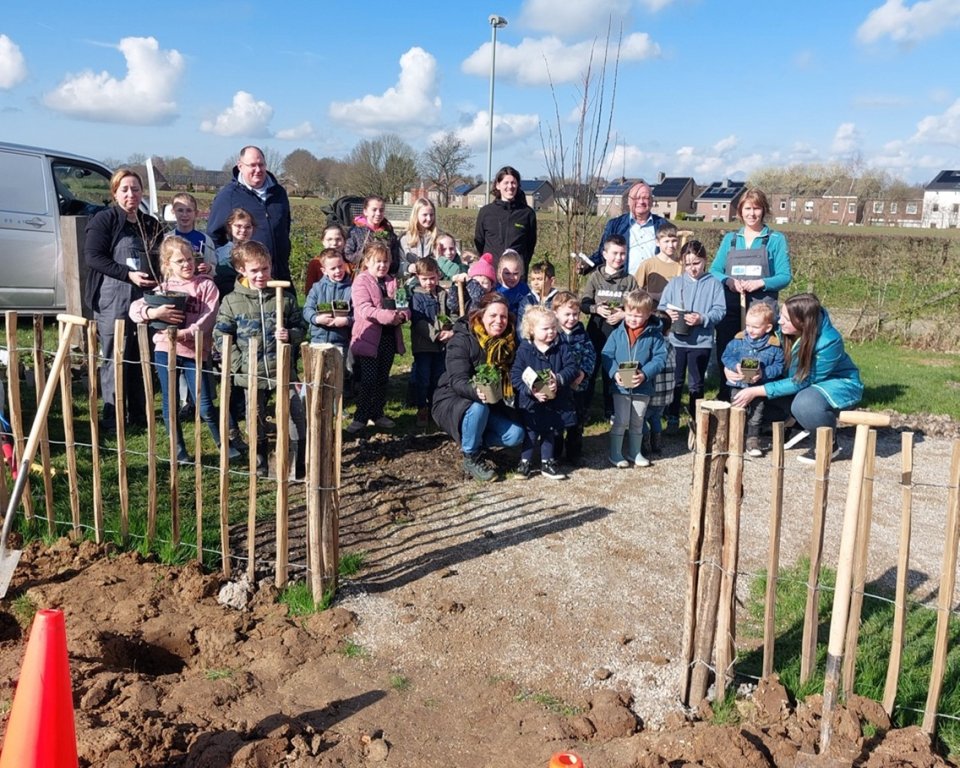 Afbeelding van leerlingen en wethouder Hodinius tijdens de plantdag van het voedselbosje in Bocholtz