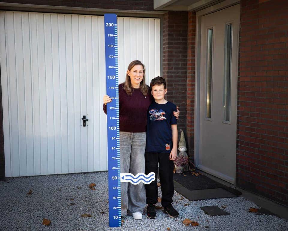 moeder en zoon wijzen tot hoe hoog het water stond