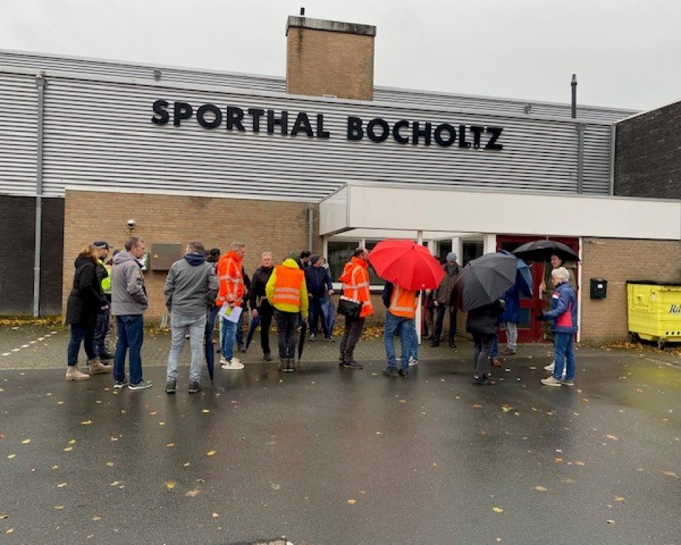 Mensen staan klaar voor de wijkschouw bij Sporthal Bocholtz