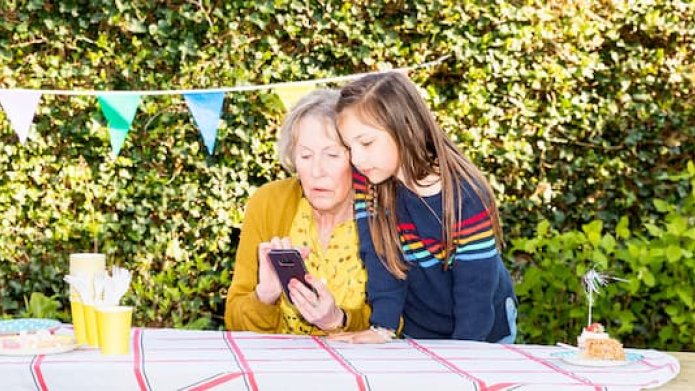 Afbeelding van oma met kleindochter met mobiele telefoon