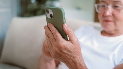 Vrouw kijkt op mobiele telefoon