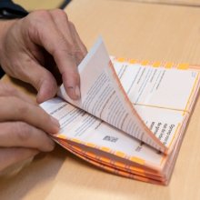 Image of two hands going through a stack of voting cards