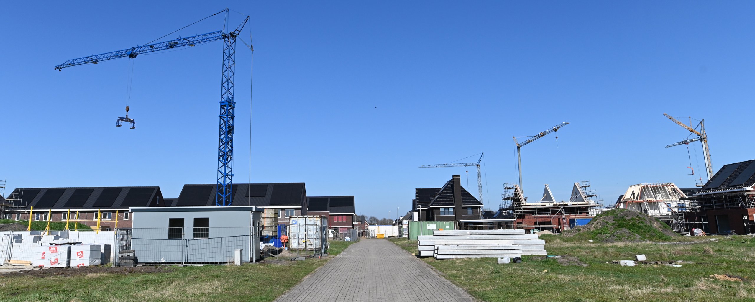 Bouwkranen torenen uit boven woningen in aanbouw