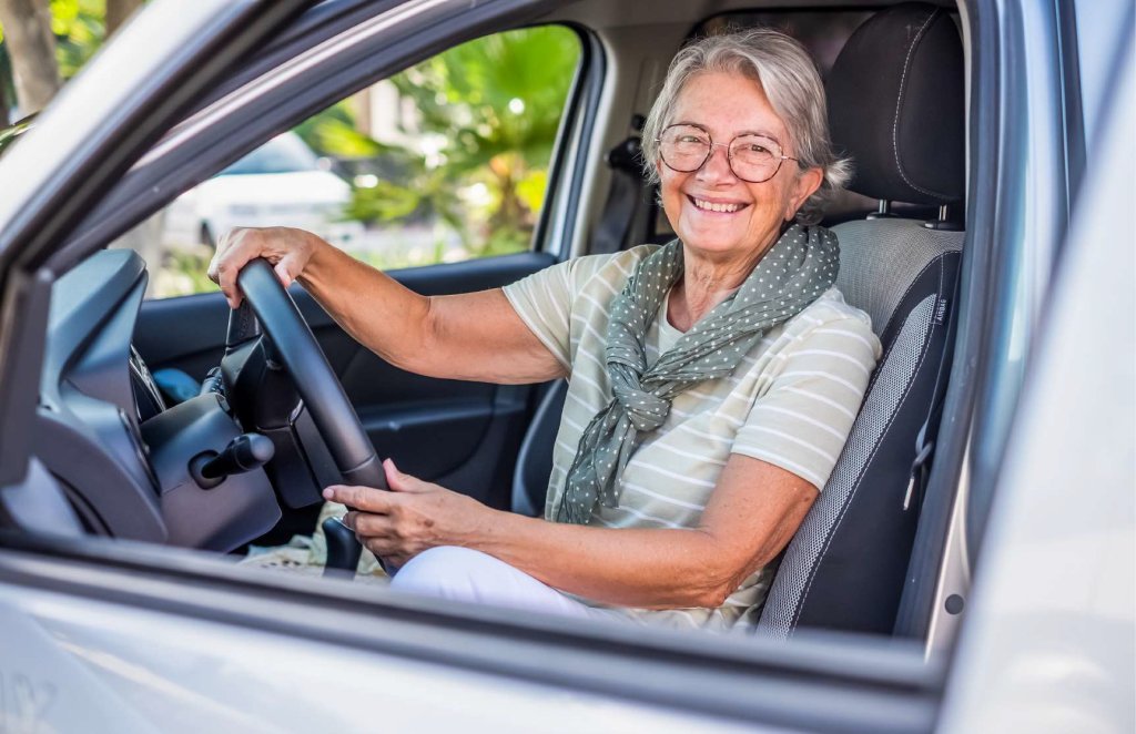 Oudere dame achter het stuur van een auto