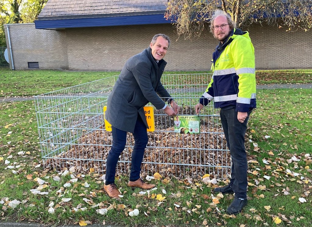 Wethouder Jan Carlo Bos plaatst met gemeentemedewerker Jasper van de Biezen een bord met uitleg op een van de bladkorven.