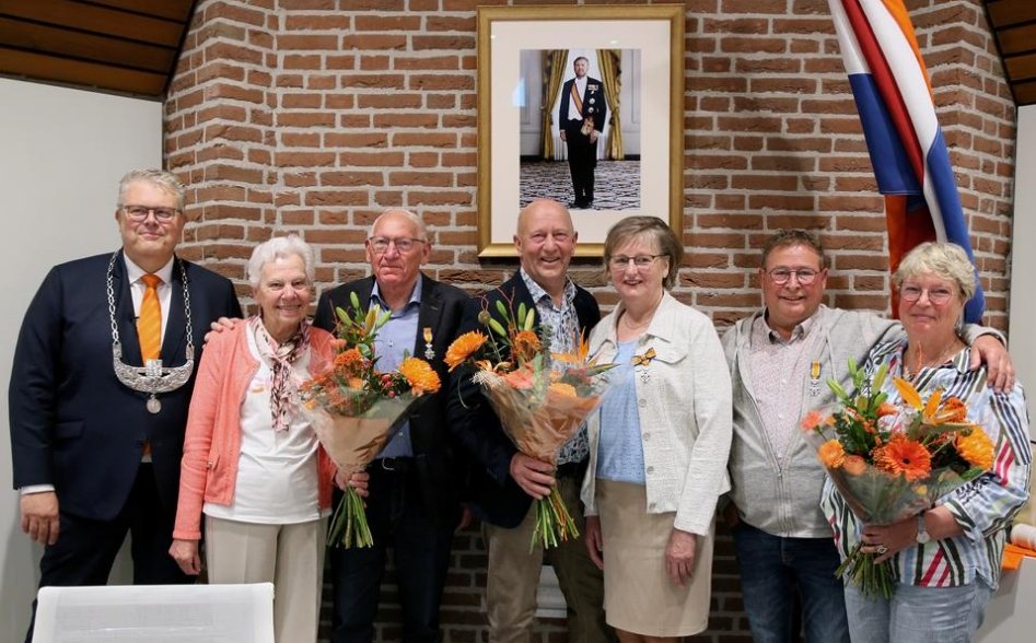 Burgemeester Jan ten Kate naast de gedecoreerden: Klaas Koobs (derde van links), Annigje van der Sluis-Meesters (vijfde van links) en Hendrie van de Weem (tweede van rechts), Op de foto staan ook de echtgenoten van de gedecoreerden. Foto: Eelco Kuiken.