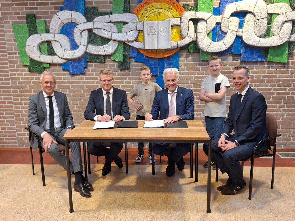 De ondertekening. Van links naar rechts: Jan Kuijers, Harm Kooiker, Leerling Luuk de Witte, wethouder Lucas Mulder, leerling Senn Dunnink, Erik Koppelman.