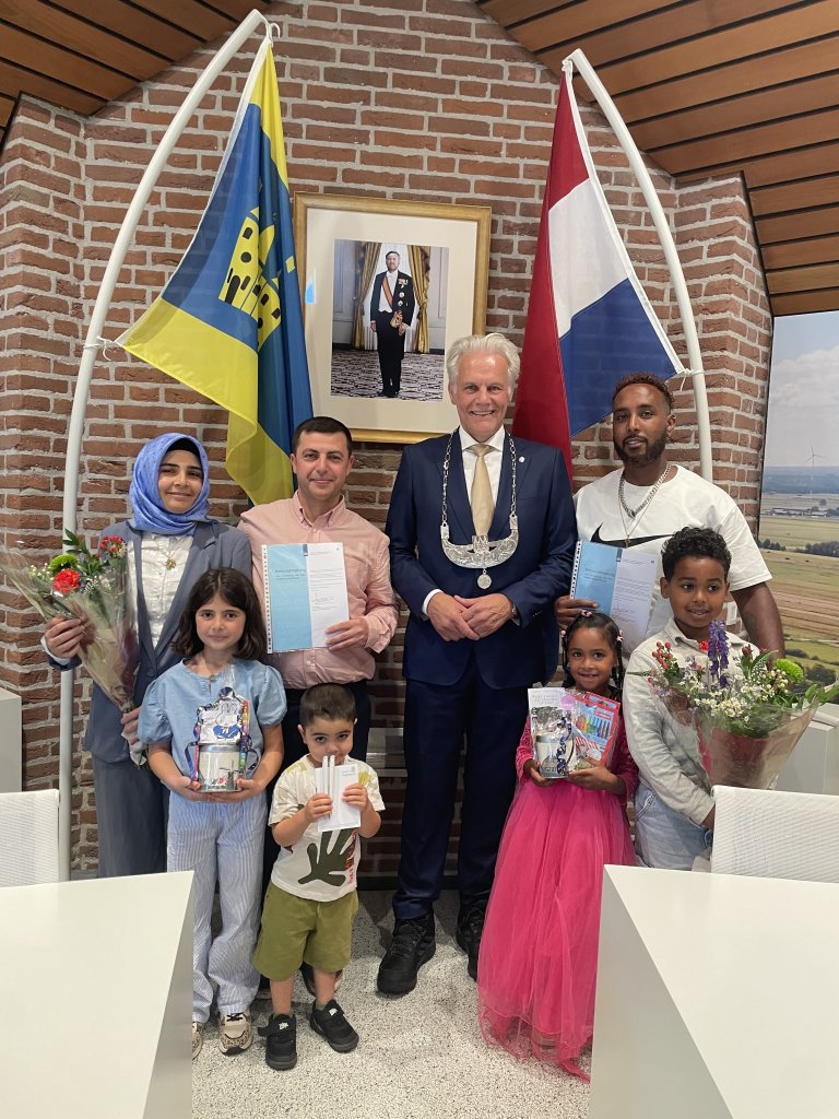 De genaturaliseerde personen met in hun midden de waarnemend burgemeester