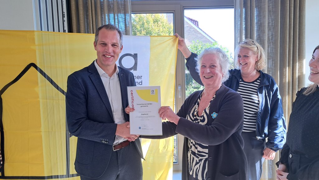 Wethouder Jan Carlo Bos neemt het certificaat Dementievriendelijke Gemeente in ontvangst van Betty Freriks.