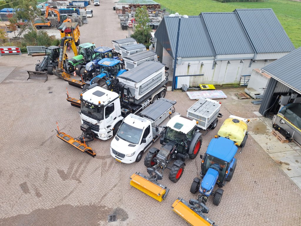 Foto van bovenaf genomen, van voertuigen van de gemeente die naast elkaar staan opgesteld op de gemeentewerf