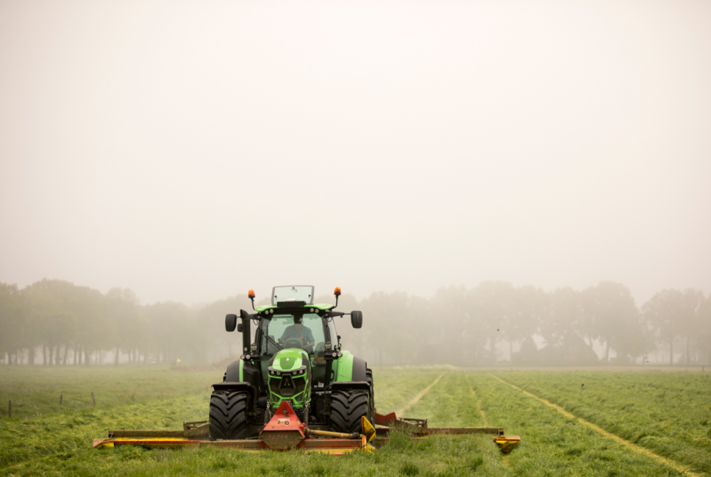 Tractor met maaier op grasland