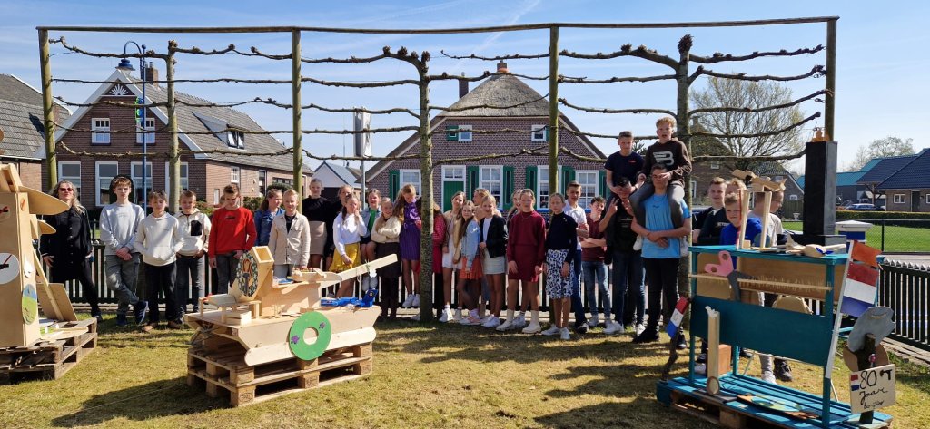 Groepsfoto van de leerlingen met voor hun de kunstwerken