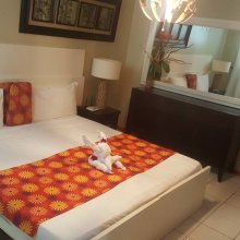 Images shows a room view of Papaya Inn with a welcoming towel animal on the bed