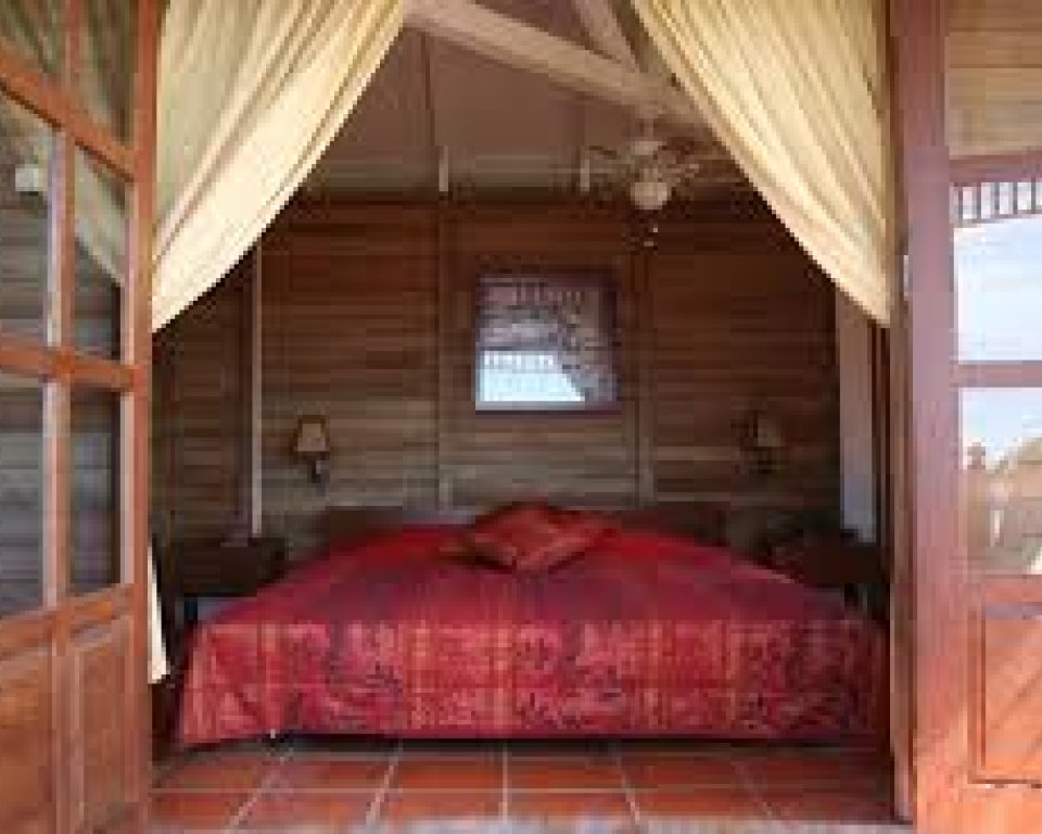 Room at Statia Lodges with the door open to display the large bed