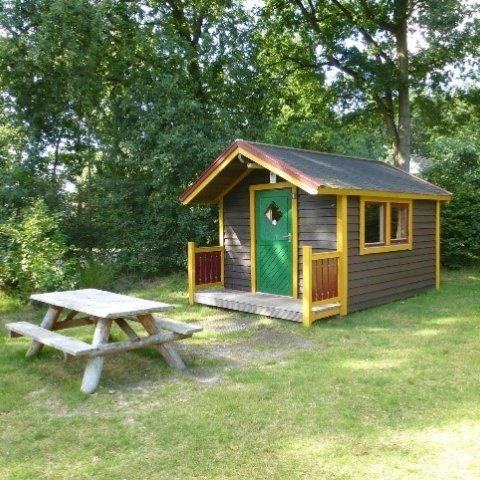 Klein houten huisje op een veld