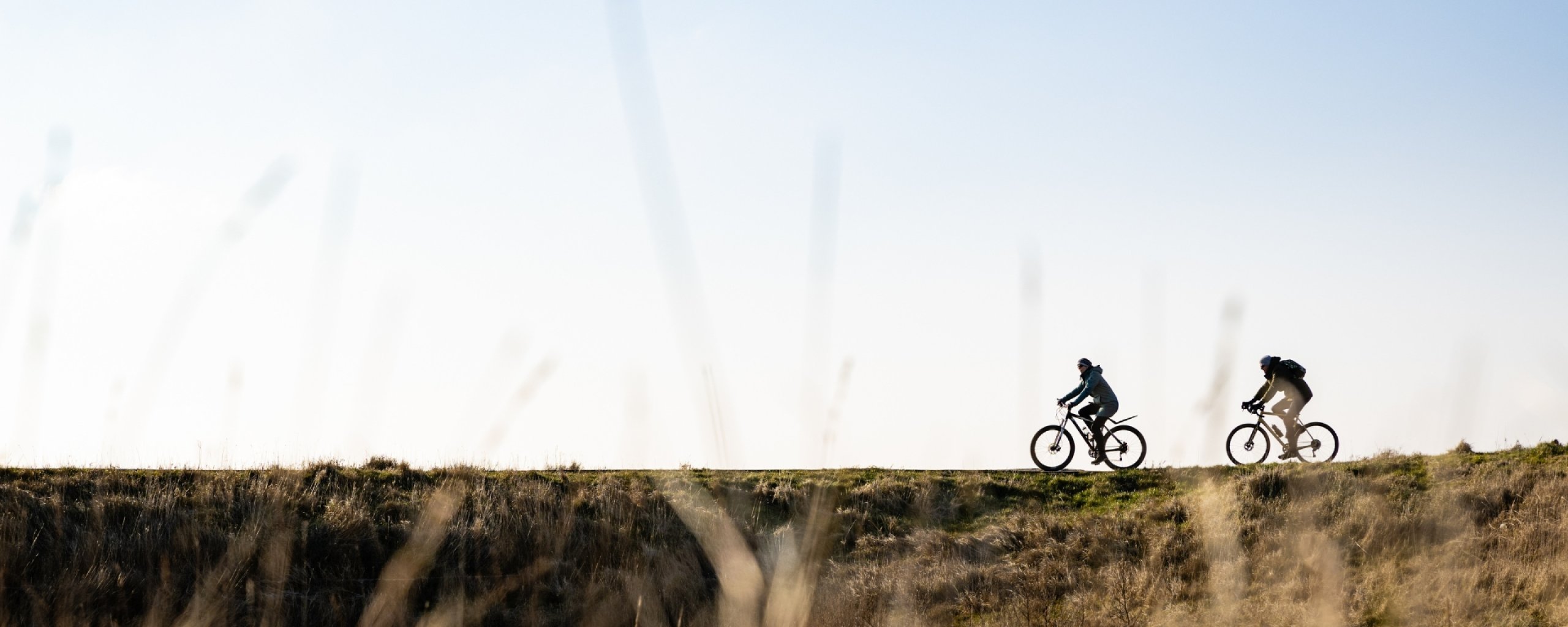 Twee mensen die fietsen op een duinpad
