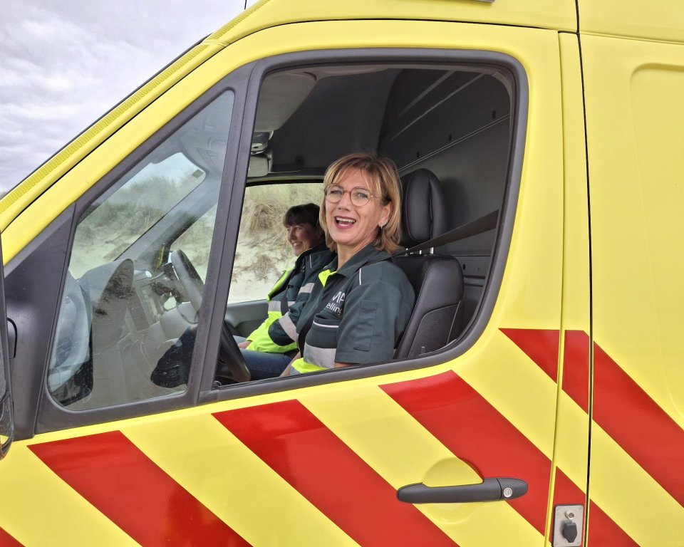 Mirjam Scheerman achter het stuur van een ambulance.