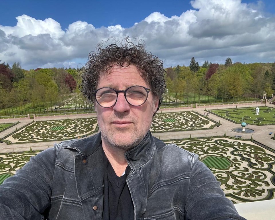 Zelfportret van Klaas Kielstra met een tuin en bomen op de achtergrond