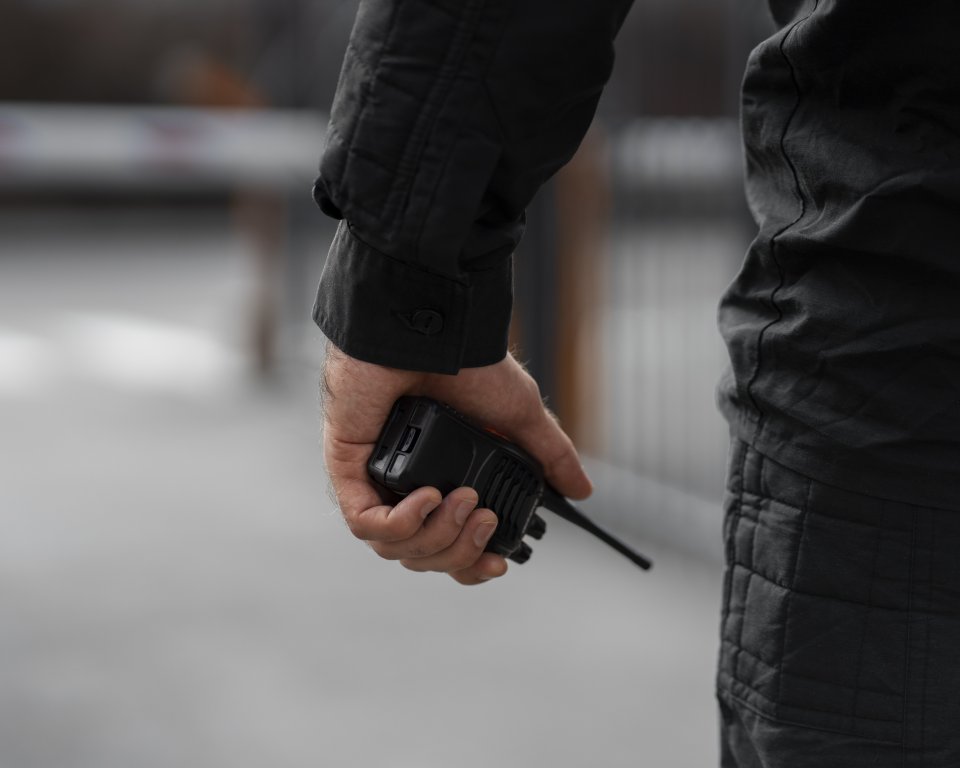 Mannelijke security met walkietalkie in de hand.