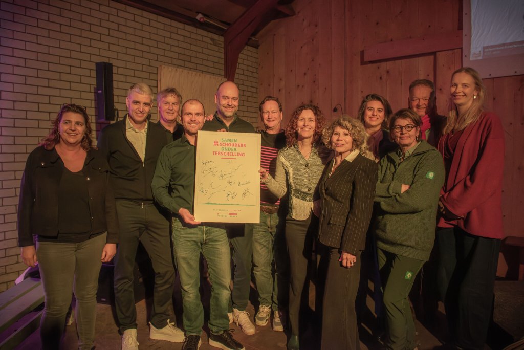 De projectgroep houdt een bord vast met daarop hun handtekeningen