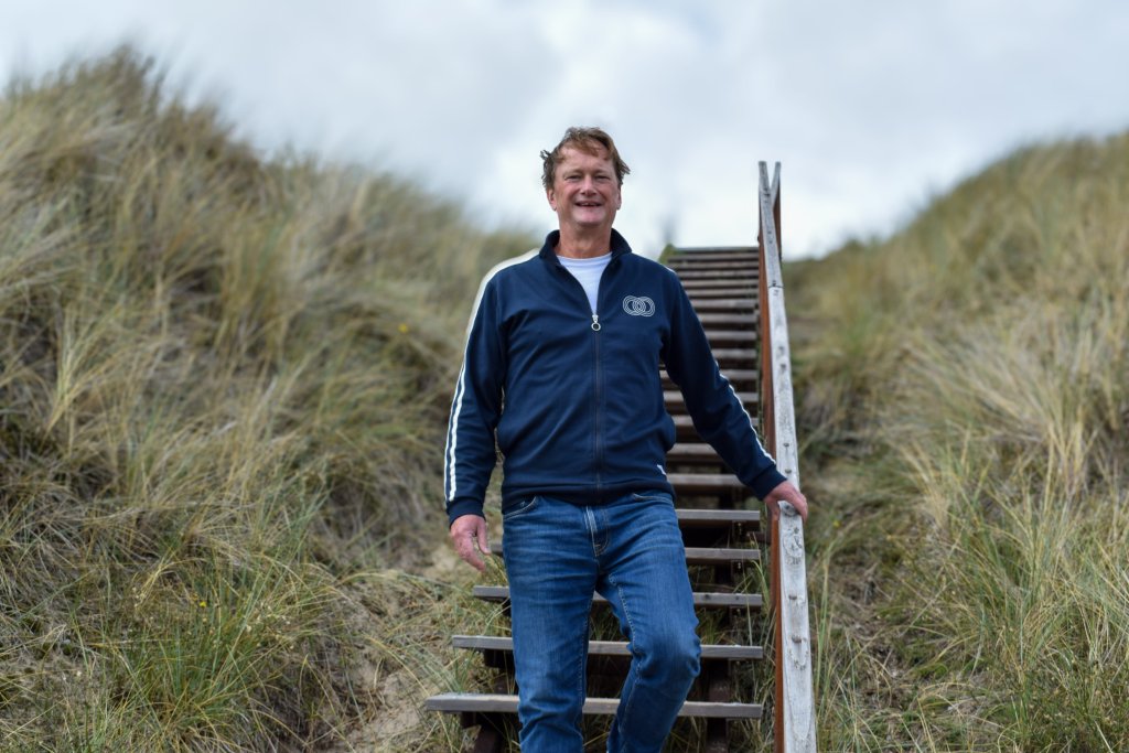 Rieme Jan loopt van een trap in de duinen en kijkt in de camera