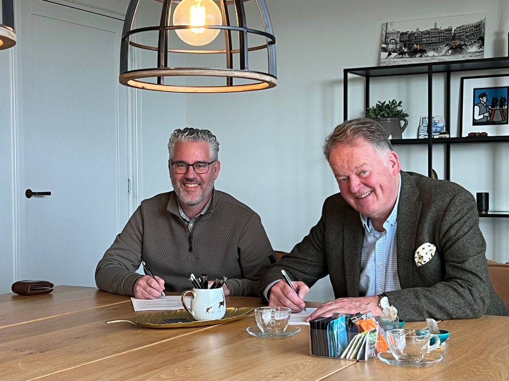 Burgemeester Roel Cazemier zit aan tafel en ondertekent de aktes 