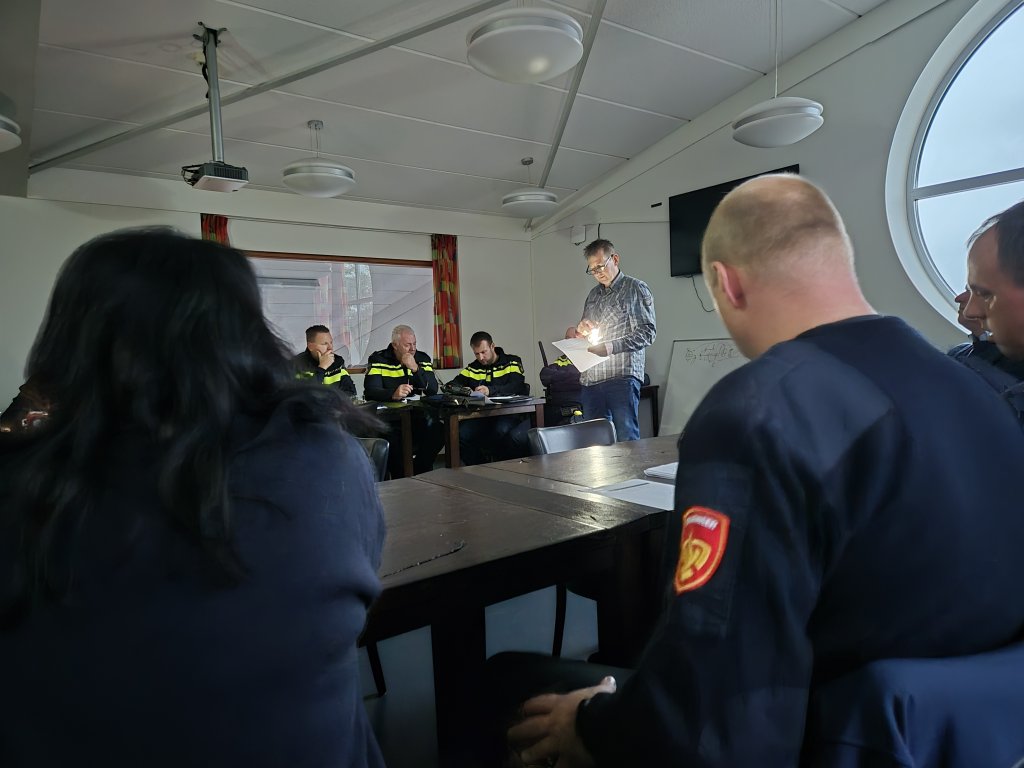 Het CoWa is in overleg met onder andere de brandweer, de politie en mensen van de gemeente. Ze zitten in het donker en lezen de informatie vanaf een papier met behulp van zaklampen.