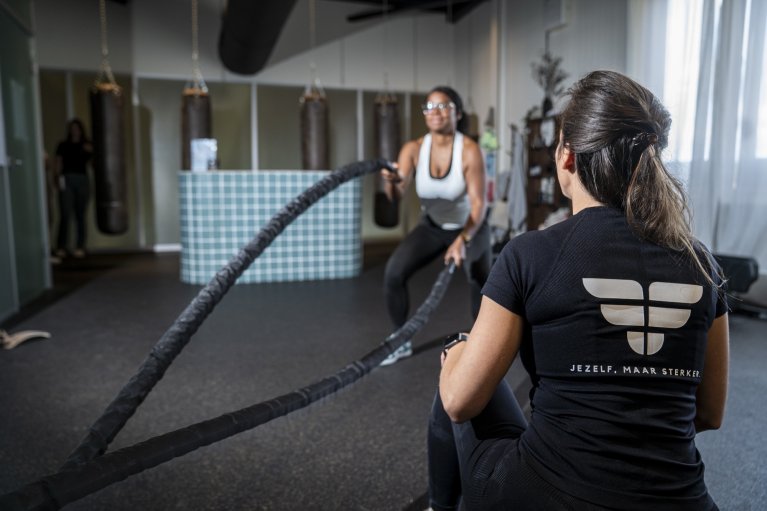 Vrouw aan het sporten met vrouwelijke begeleider