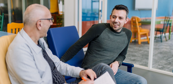 Twee mannen spreken op een vrolijke manier met elkaar.