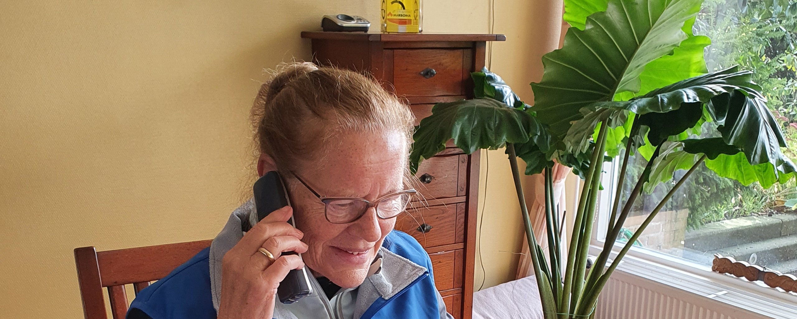 Een oudere mevrouw houdt telefonisch spreekuur voor vragen over het openbaar vervoer