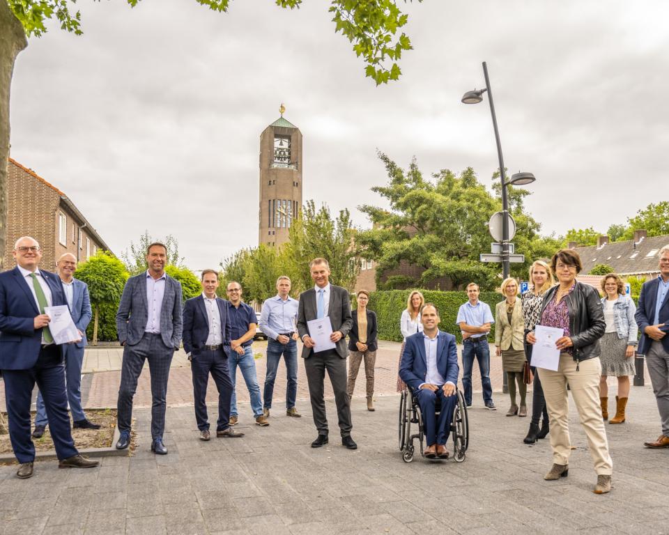 Medewerkers van de gemeente Dronten, Urk en Noordoostpolder staan op het plein voor het gemeentehuis in Emmeloord na ondertekening van de overeenkomst voor de levering van WMO-hulpmmiddelen 