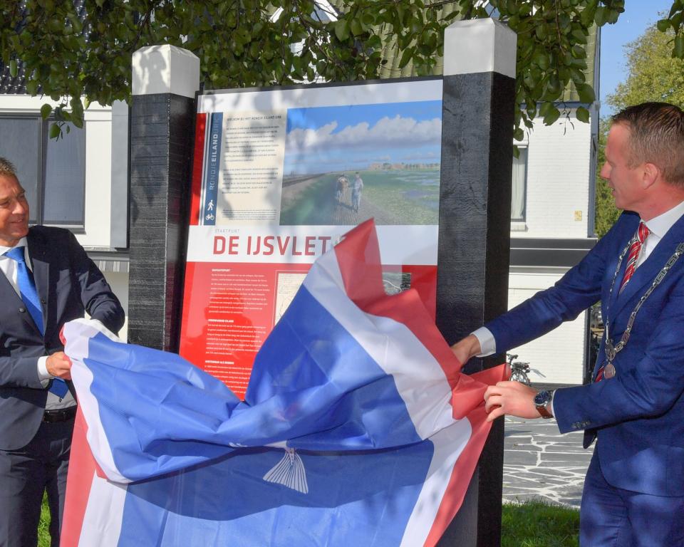 Wethouder Freek Brouwer en burgemeester Cees van den Bos onthullen het eerste informatiepaneel van de wandelroute Rondje Eiland Urk