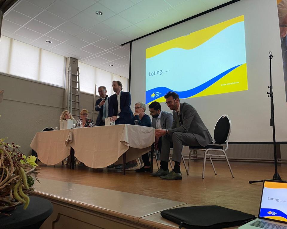 Medewerkers gemeente en wethouders met een notaris die de loting verricht voor kavels van de Zeeheldenwijk op Urk