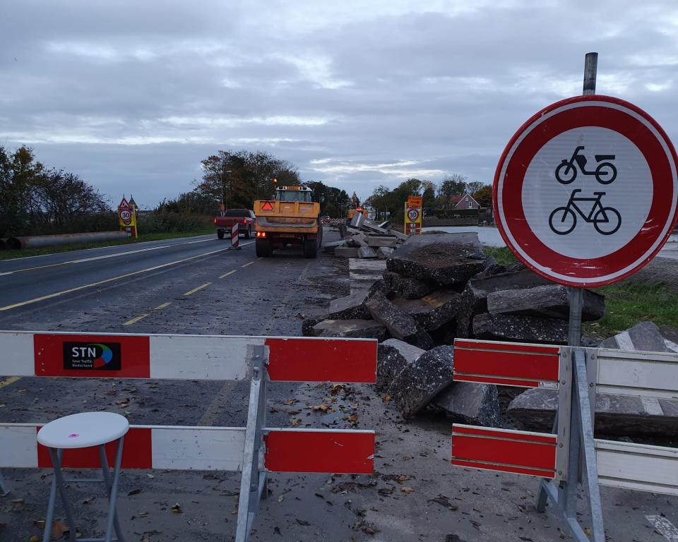 Roodwitte hekken voor een weg met een verbodsbord voor fietsers en bromfietsers