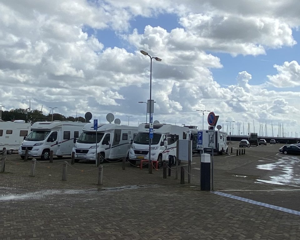 Campers op het haventerrein van Urk met veel wolken in een blauwe lucht