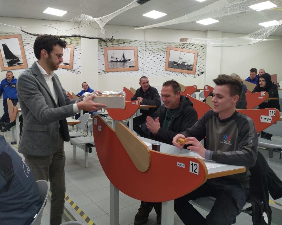 Wethouder Nathanaël Middelkoop overhandigt een lekkernij in de IJsselmeerafslag