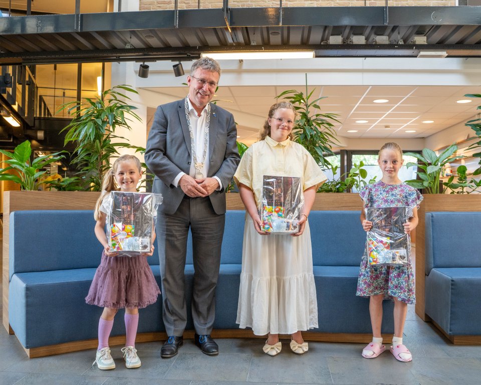 De burgermeester met de prijswinnaars van de kleurwedstrijd.