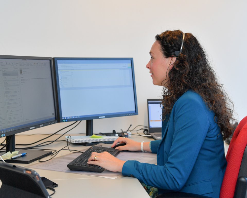 Vrouw zit achter bureau aan het bellen