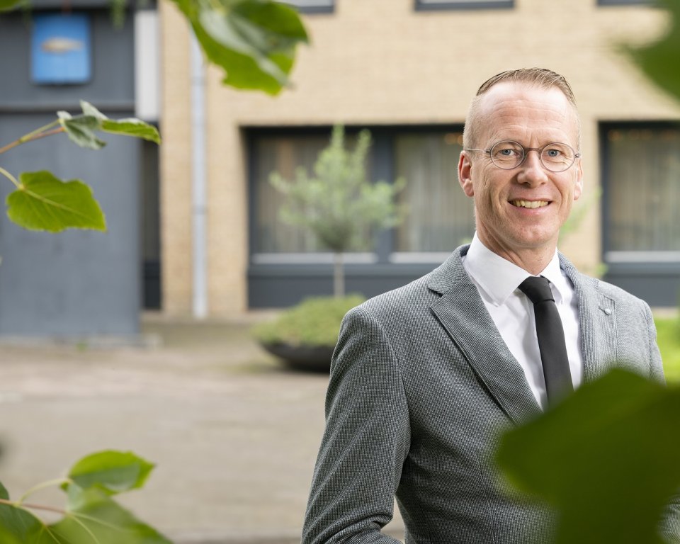 Burgemeester Cees van den Bos staat voor het gemeentehuis van Urk